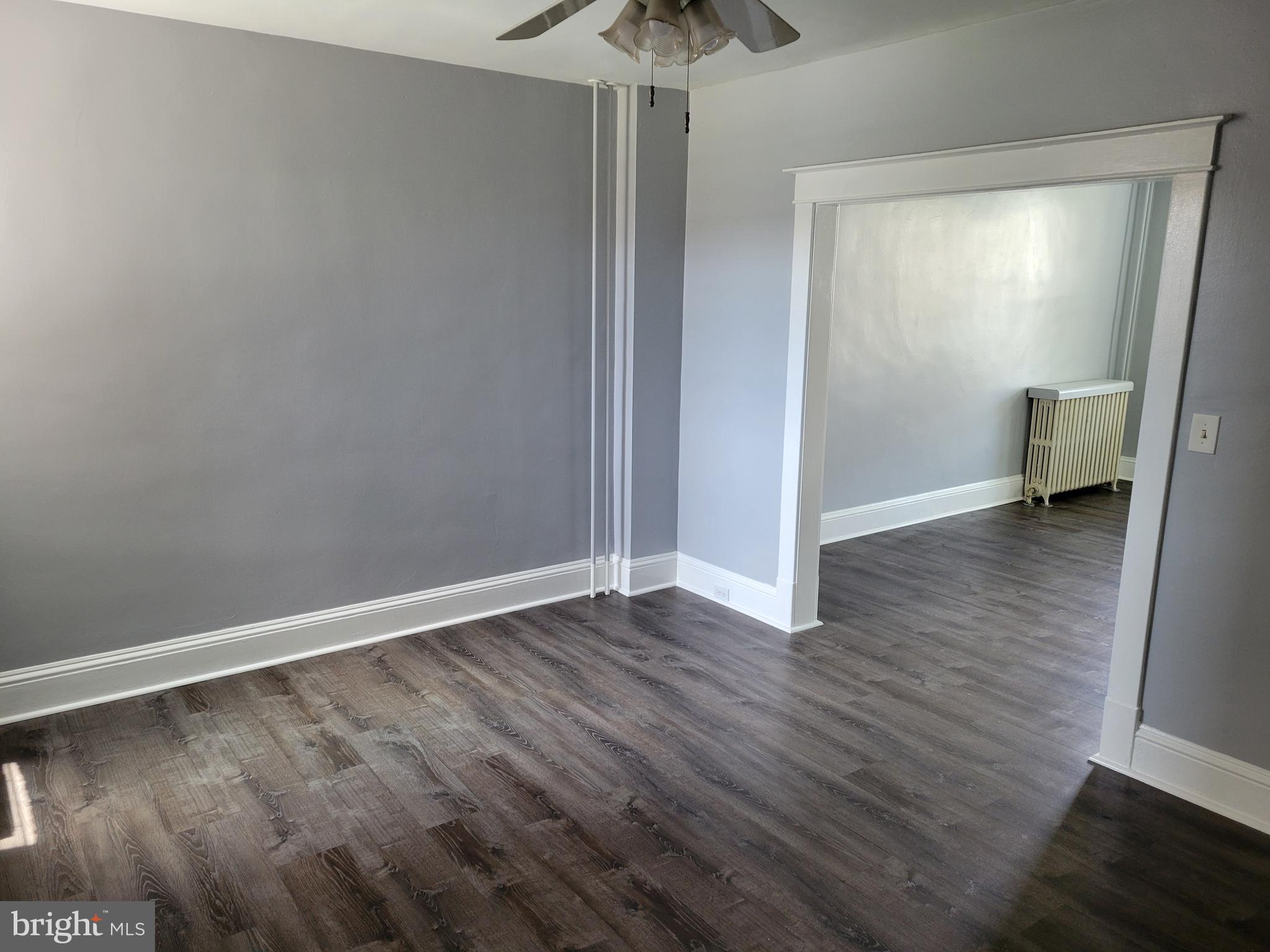 6757 Woodley Road Dundalk, MD 21222 - Photo 9 of 27 a view of an empty room with wooden floor and a window