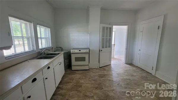 a kitchen with granite countertop a sink stove and refrigerator