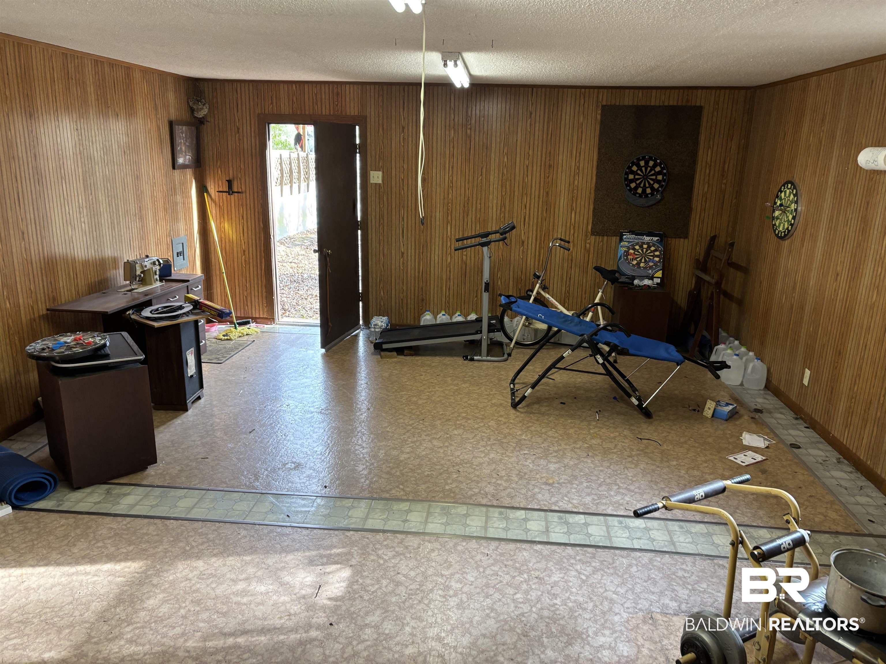 15575 Rogers Drive Chunchula, AL 36521 - Photo 23 of 42 Exercise room featuring wooden walls, light floors, and a textured ceiling