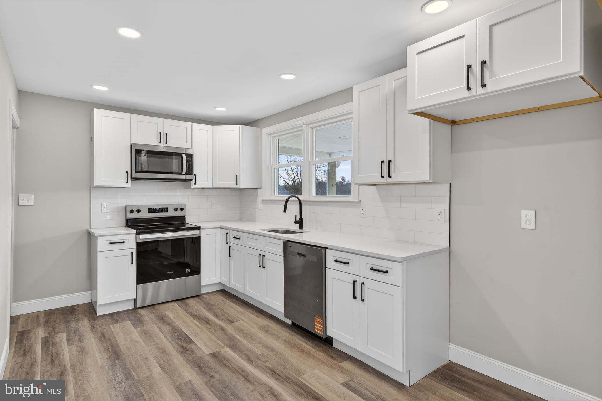 5960 Clover Road Harrisburg, PA 17112 - Photo 11 of 39 a kitchen with stainless steel appliances granite countertop a stove top oven a sink a microwave and cabinets