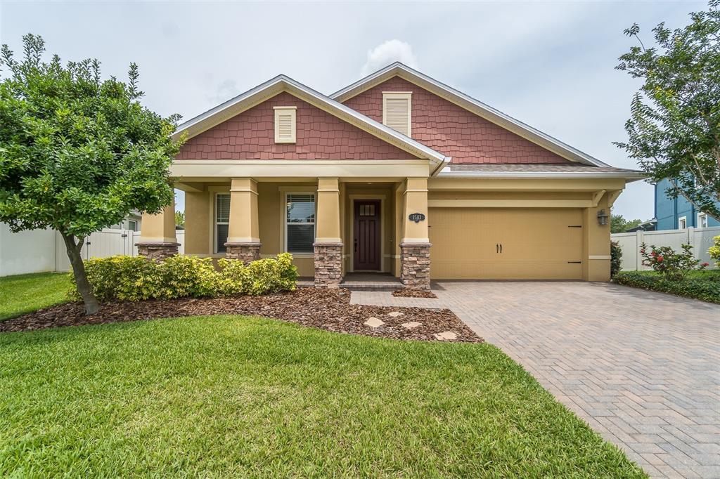 a front view of a house with a garden and yard