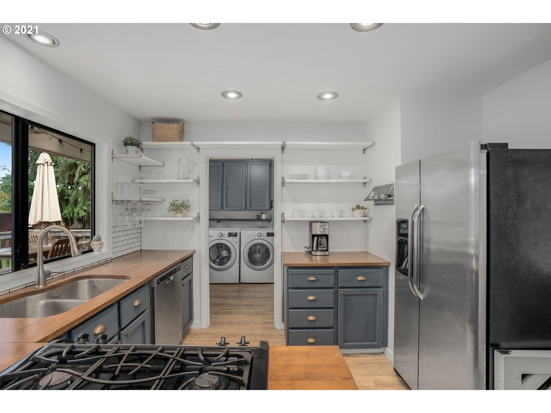 7408 Southwest Mapleleaf Street Portland, OR 97223 - Photo 10 of 32 a kitchen with stainless steel appliances kitchen island granite countertop a refrigerator and a sink