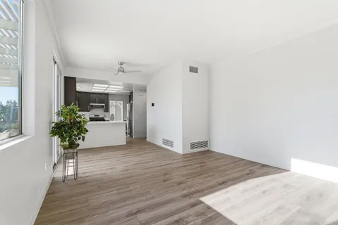 a view of a kitchen and an entryway with wooden floor