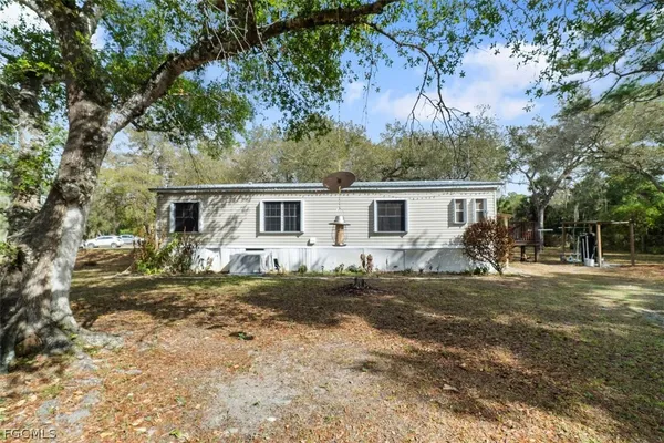 a view of a yard in front of a house with large tree
