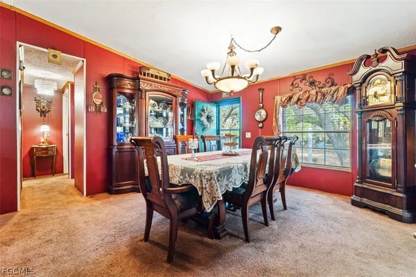 a dining room with furniture a chandelier and a rug