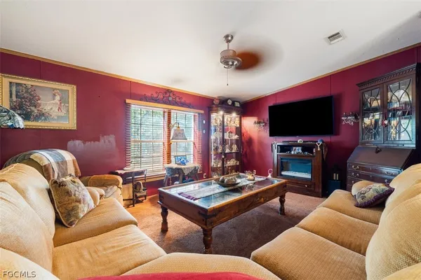 a living room with furniture ceiling fan and a flat screen tv