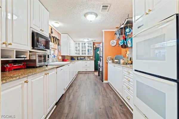 a kitchen with stainless steel appliances granite countertop lots of counter top space and wooden floor