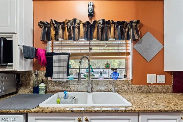 a view of a kitchen with granite countertop a sink and a stove