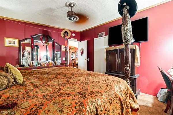 a spacious bedroom with a bed and a flat screen tv