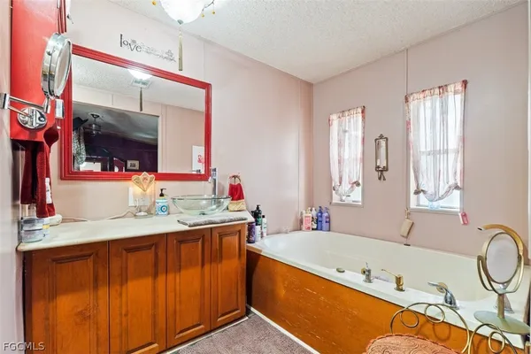 a bathroom with a tub a sink and a mirror