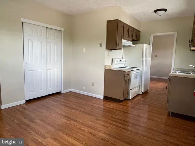 a kitchen with stainless steel appliances a stove top oven a sink and a refrigerator