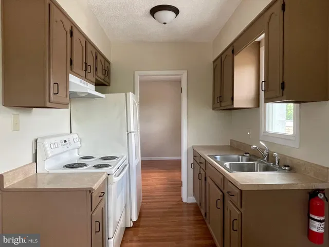 a kitchen with a sink a stove and a refrigerator