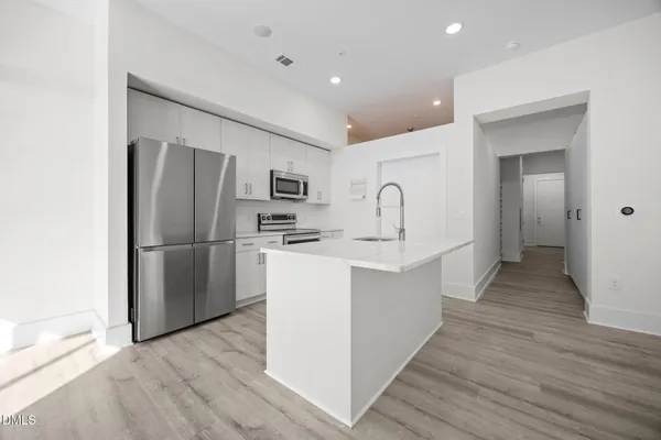 a kitchen with refrigerator cabinets and wooden floor