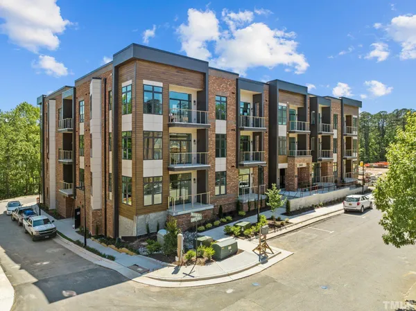 a view of a building with floor to ceiling windows and yard