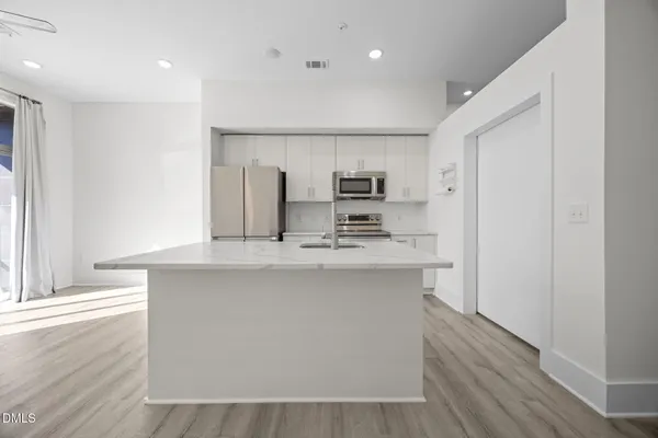 a kitchen with kitchen island a sink stainless steel appliances and cabinets