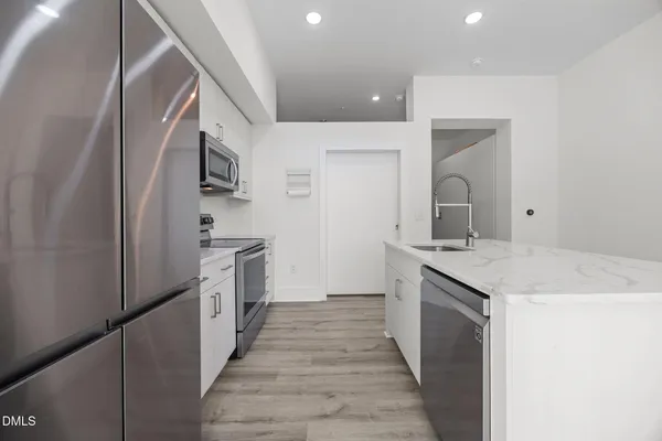 a kitchen with granite countertop a sink and refrigerator