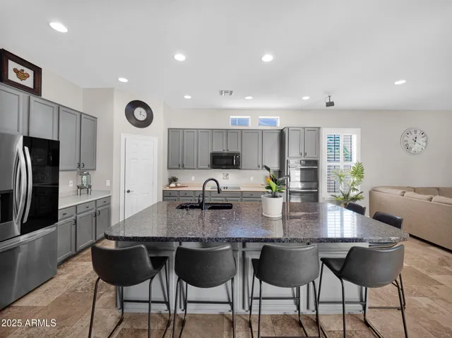 a kitchen with stainless steel appliances granite countertop a sink a stove and a refrigerator