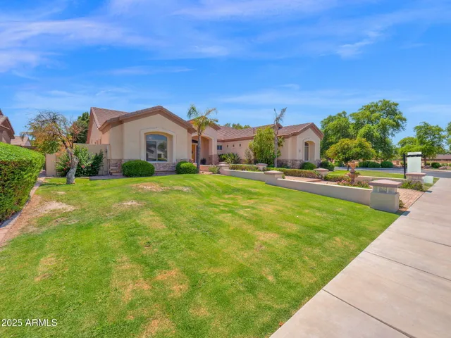 a view of a house with a big yard plants and large trees