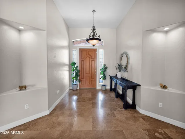a living room with furniture a chandelier and a table
