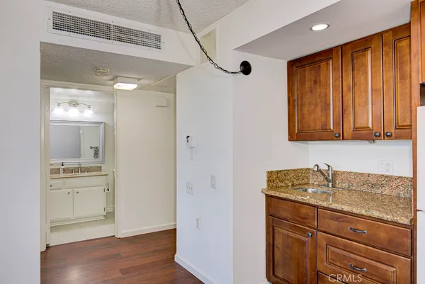 a bathroom with a granite countertop sink a mirror and a shower