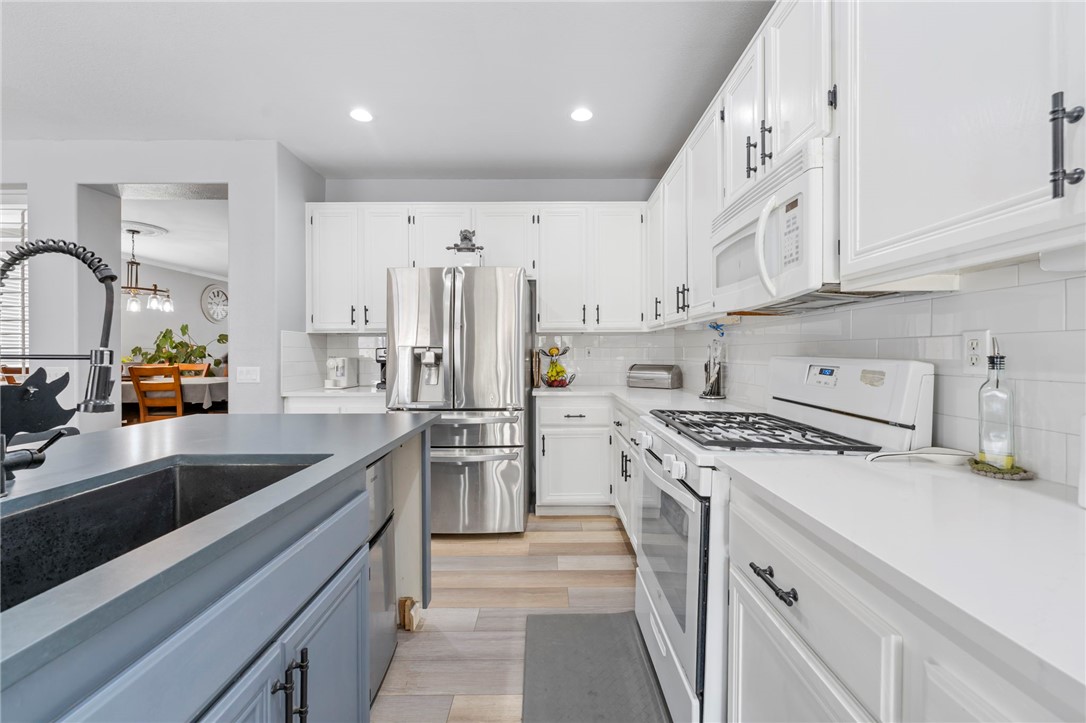 3155 Shipley Place Hemet, CA 92545 - Photo 11 of 26 a kitchen with white cabinets and stainless steel appliances