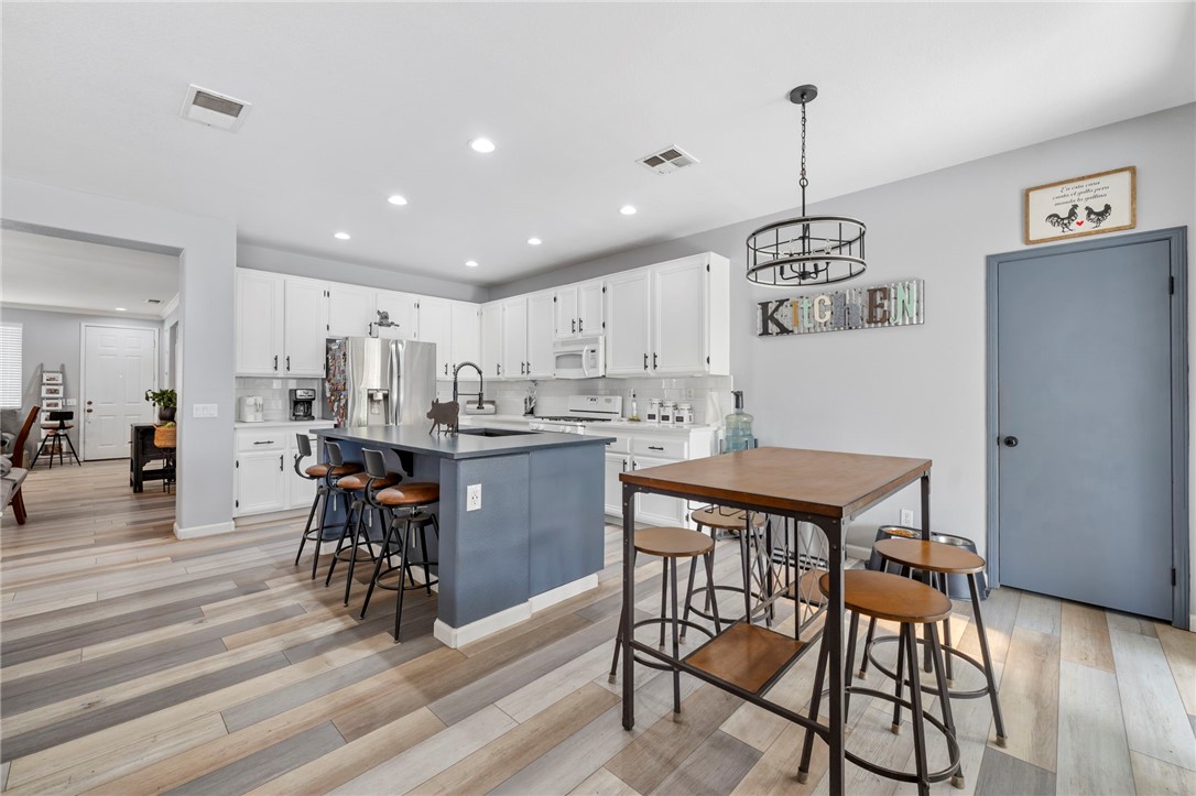 3155 Shipley Place Hemet, CA 92545 - Photo 9 of 26 a kitchen with stainless steel appliances kitchen island granite countertop a table chairs sink and cabinets