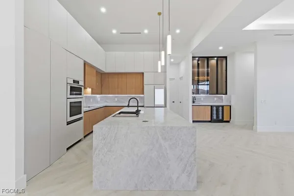 a large kitchen with stainless steel appliances kitchen island a large counter top
