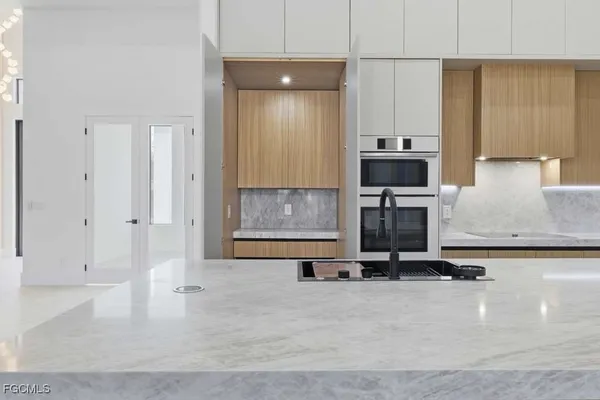a kitchen with kitchen island a counter top space cabinets and stainless steel appliances