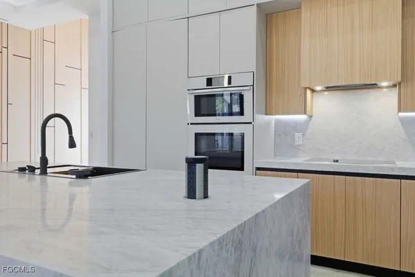 a kitchen with stainless steel appliances granite countertop a sink a stove and a refrigerator