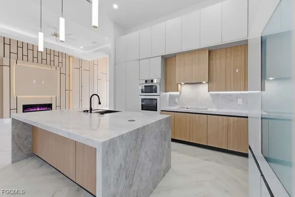 a large kitchen with a center island a counter space stainless steel appliances and cabinets