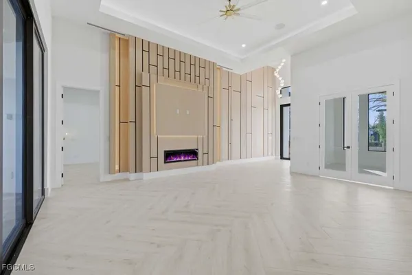 a view of a big room with a chandelier fan and windows