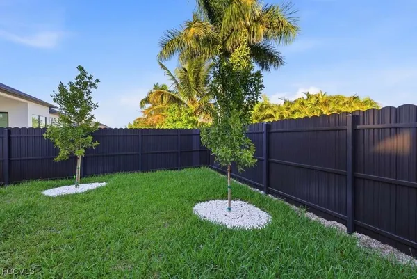 a view of a backyard with a potted plants and wooden fence