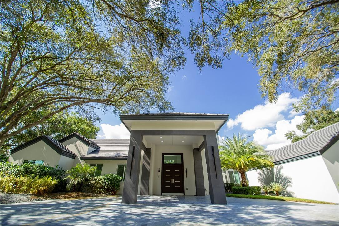 a front view of a house with a tree