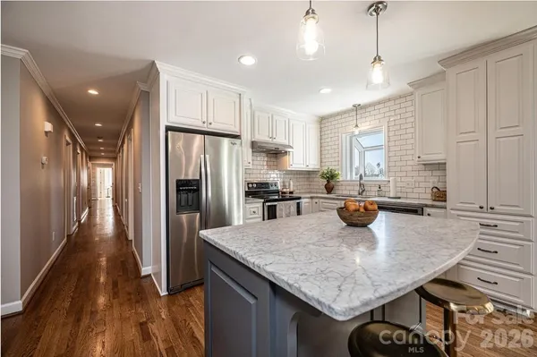 a kitchen with stainless steel appliances granite countertop a sink refrigerator and cabinets