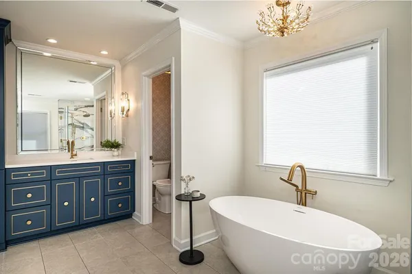 a bathroom with a double vanity sink mirror and bathtub