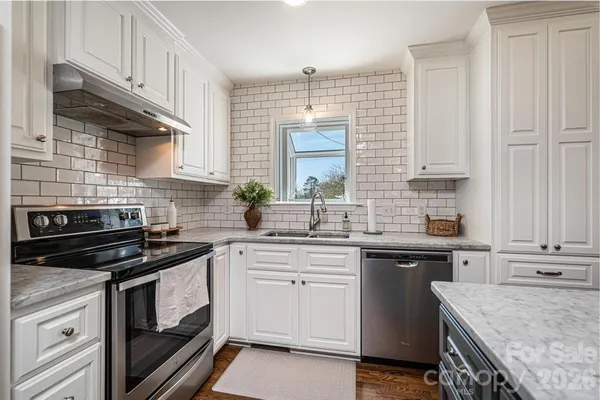a kitchen with cabinets stainless steel appliances and sink