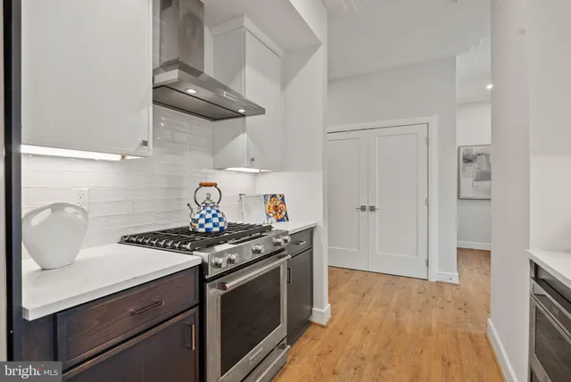 a kitchen with stainless steel appliances a sink stove and cabinets