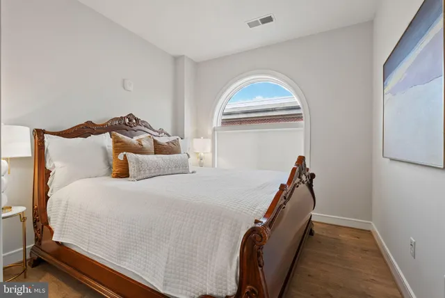 a bedroom with a bed and a large window