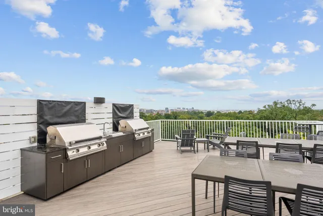 a view of a roof deck with table and chairs couches with wooden floor
