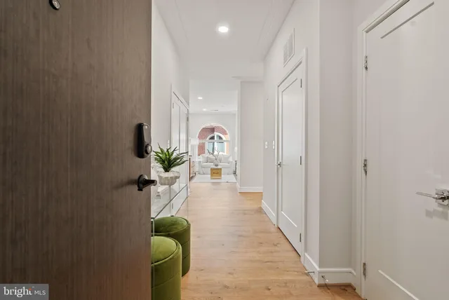 a hallway with wooden floor and a potted plant