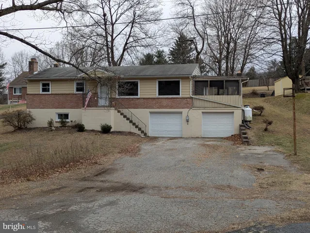 a view of a white house with a large space in front of it