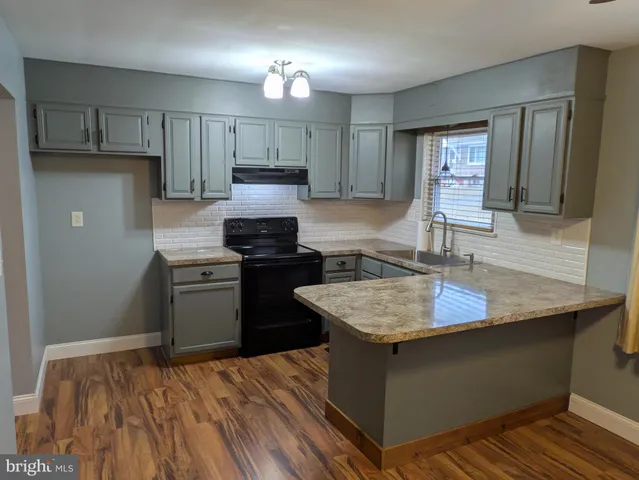 a kitchen with kitchen island granite countertop a sink stove and refrigerator