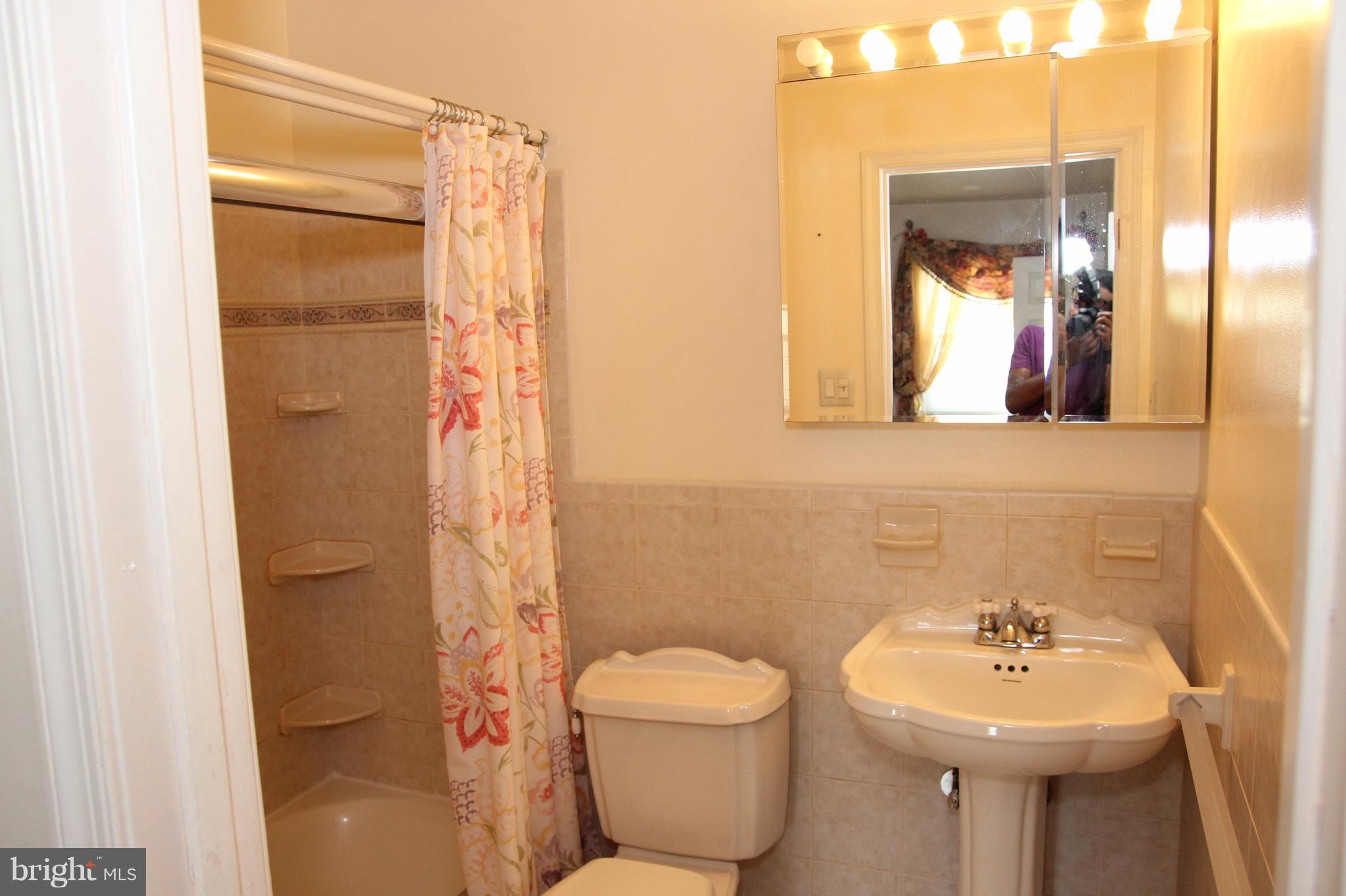 3413 Dunnington Road Beltsville, MD 20705 - Photo 7 of 16 a bathroom with a sink mirror toilet and shower