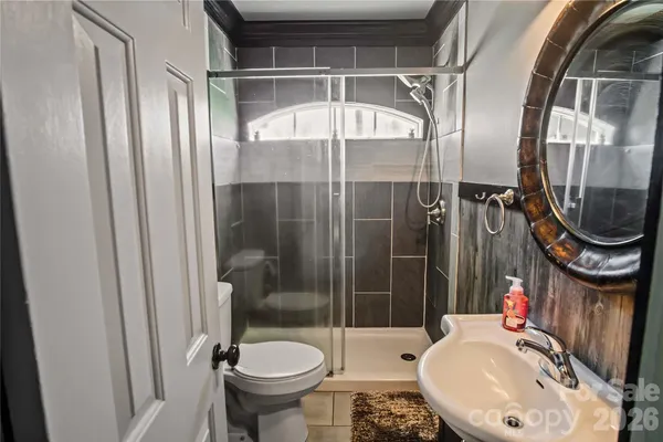 a bathroom with a granite countertop sink toilet and mirror