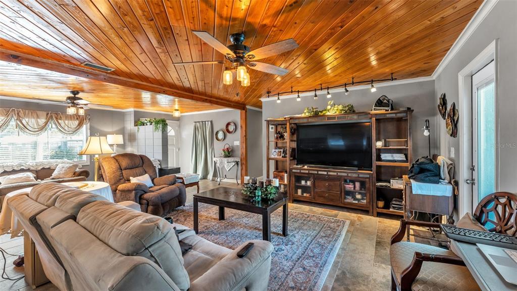 3830 Clubhouse Road Lakeland, FL 33812 - Photo 13 of 42 a living room with furniture a flat screen tv and a floor to ceiling window