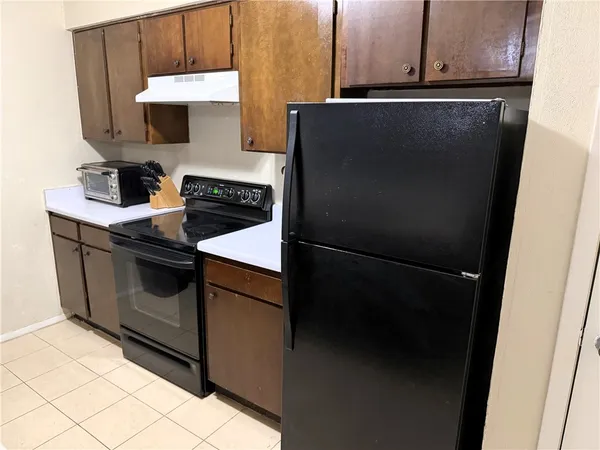 a kitchen with stainless steel appliances granite countertop a refrigerator a stove and a sink