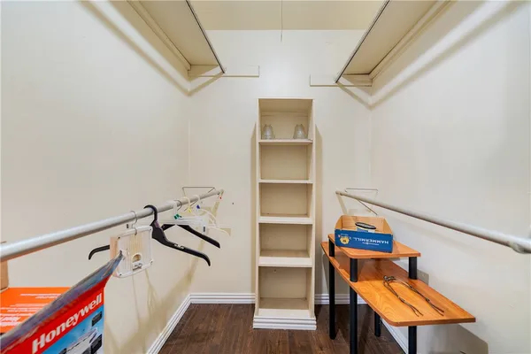 a view of stairs and an empty room with wooden floor