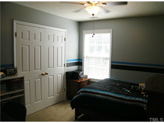 4925 Mocha Lane Raleigh, NC 27616 - Photo 19 of 25 a bedroom with a bed and a chandelier