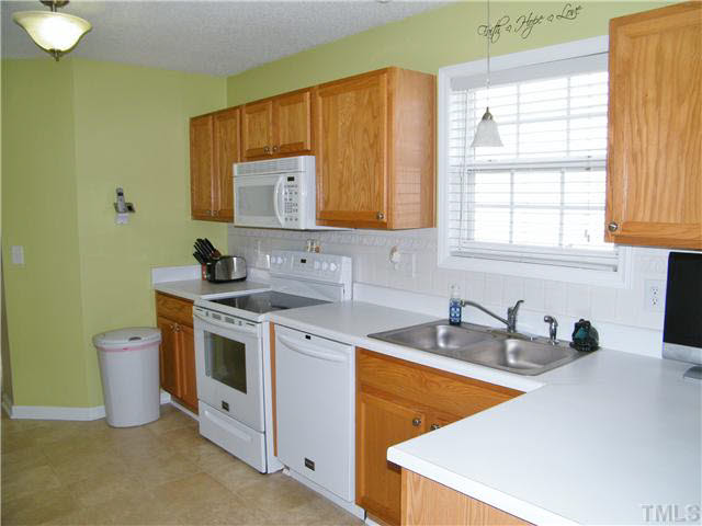 4925 Mocha Lane Raleigh, NC 27616 - Photo 6 of 25 a kitchen with stainless steel appliances granite countertop a sink stove and cabinets