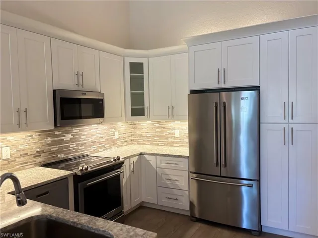 a kitchen with granite countertop stainless steel appliances and wooden cabinets